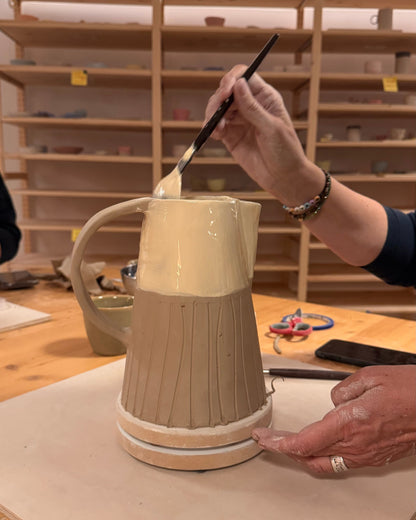 couleur crème sur le haut d’un pichet en argile à base striée pendant un atelier.