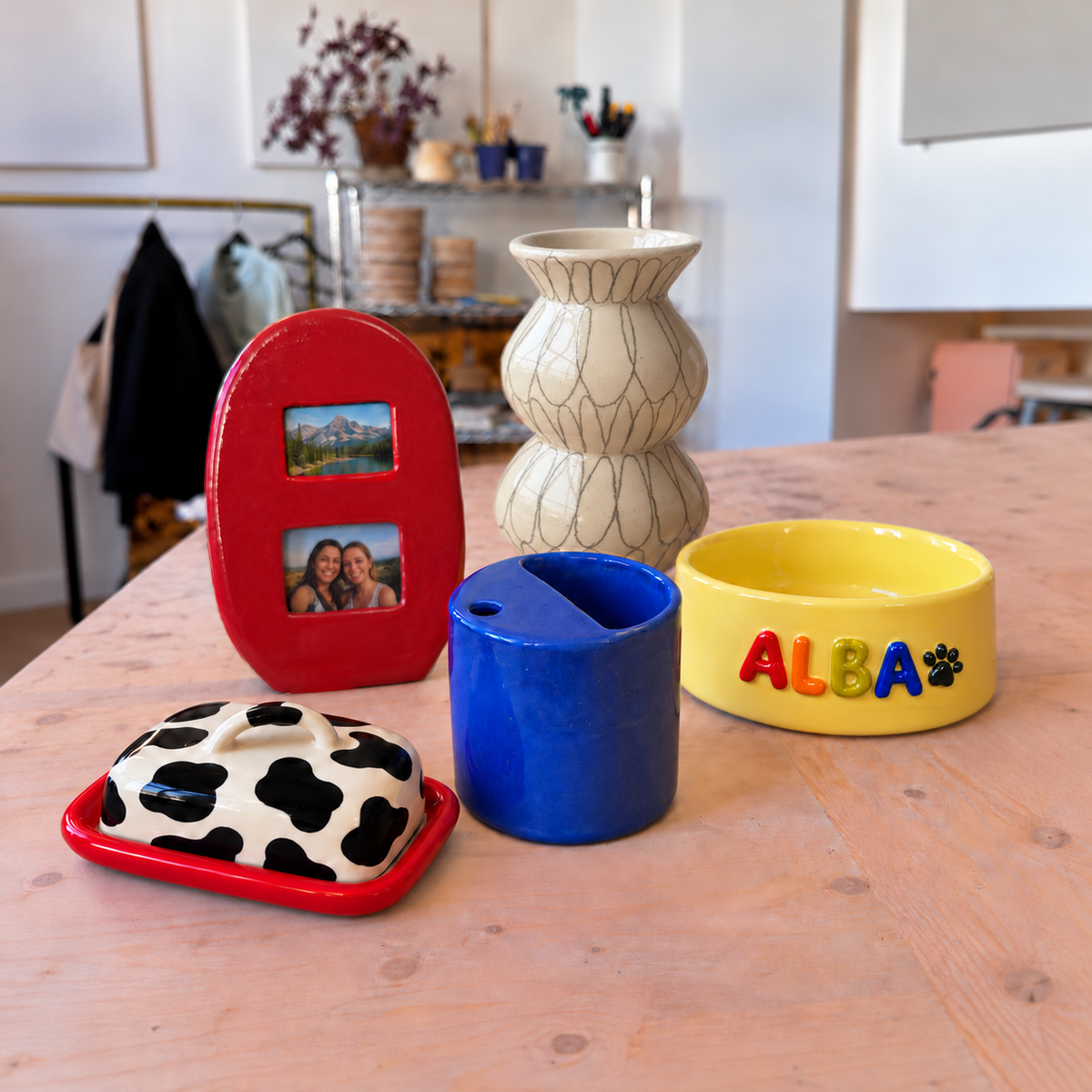 Vase, cadre photo, tasse bleue, beurrier à taches et gamelle personnalisée en céramique au Super Atelier.